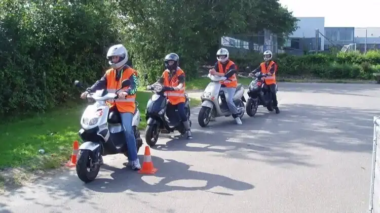 En gruppe unge kører på scooter for at tage kørekort